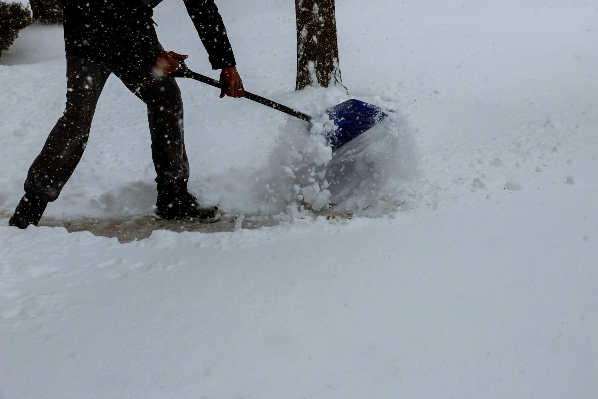 man-shoveling-snow-from-the-sidewalk-in-front-of-his-house-after-a-heavy-snowfall-in-a-city-man