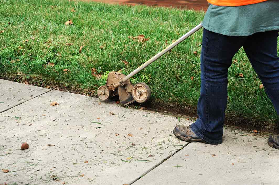 Elite Lawn Care Team Edging A Lawn